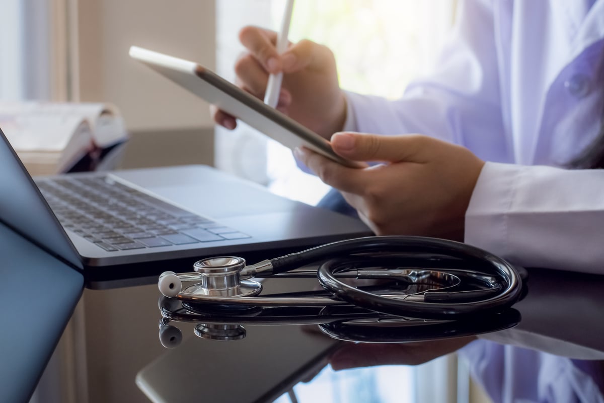 Doctor using digital tablet, work on laptop computer, Telehealth, telemedicine concept.