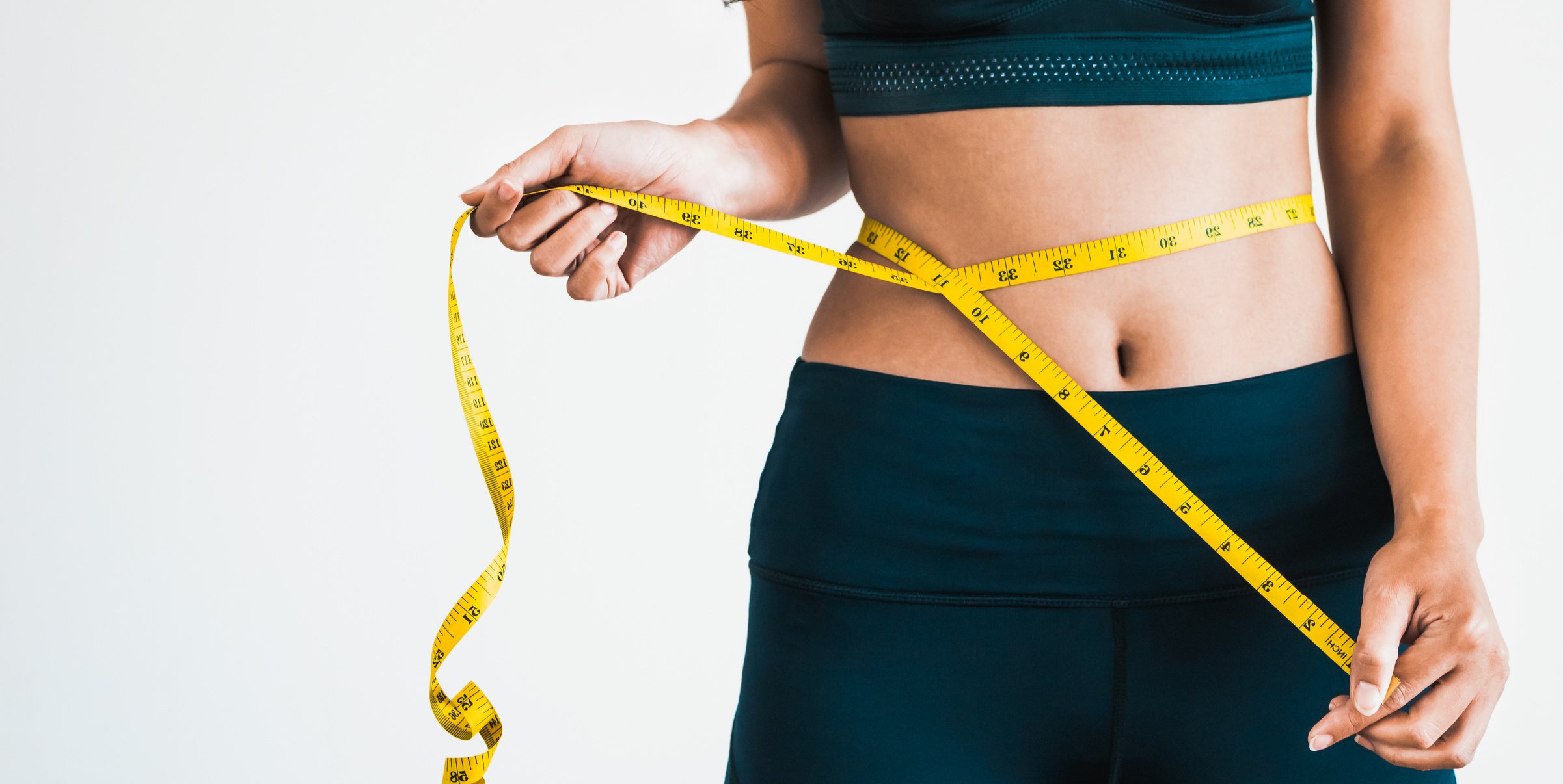 Close up shot woman with slim body measuring torso